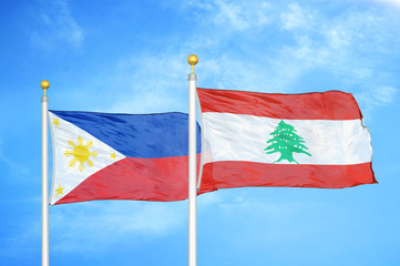 Philippines and Lebanon two flags on flagpoles and blue cloudy sky