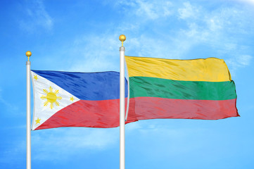 Philippines and Lithuania two flags on flagpoles and blue cloudy sky