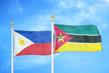 Philippines and Mozambique two flags on flagpoles and blue cloudy sky