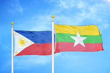 Philippines and Myanmar two flags on flagpoles and blue cloudy sky