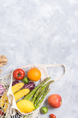 Different farm fruits and vegetables in a home bag. Gray background. The concept of healthy eating.