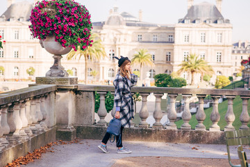 Obraz premium Happy girl in a mikimaus hat in the Luxembourg garden and the Palace in Paris.