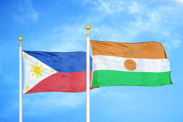Philippines and Niger two flags on flagpoles and blue cloudy sky