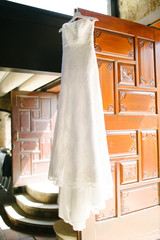 A white wedding dress hanged on the hanger. Preparations for the wedding day.