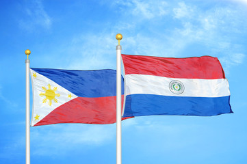 Philippines and Paraguay two flags on flagpoles and blue cloudy sky