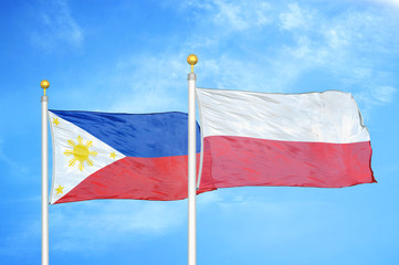 Philippines and Poland two flags on flagpoles and blue cloudy sky