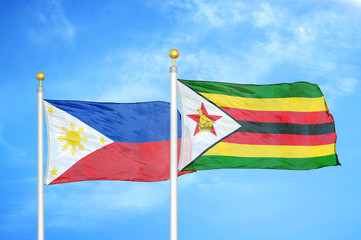 Philippines and Zimbabwe two flags on flagpoles and blue cloudy sky