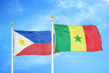 Philippines and Senegal two flags on flagpoles and blue cloudy sky