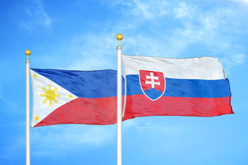 Philippines and Slovakia two flags on flagpoles and blue cloudy sky