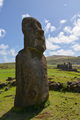 singular Ancient maoi statue in landscape with mountain and feilds