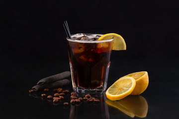 delicious cocktail drink in old fashion glass with lemon on the black background coffee beans on the glass