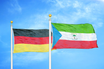 Germany and Equatorial Guinea two flags on flagpoles and blue cloudy sky