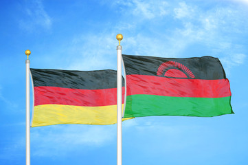 Germany and Malawi two flags on flagpoles and blue cloudy sky
