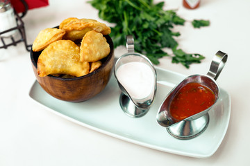 Pastry with greens and sacks on a wooden surface