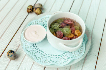 rainbow dumplings for children on a wooden background with flowers and quail eggs