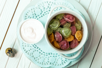 rainbow dumplings for children on a wooden background with flowers and quail eggs
