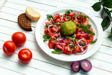 salad with baked mozzarella cheese with onions and tomatoes on a wooden surface