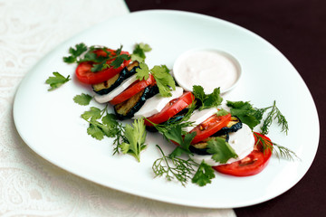 fried eggplant with tomatoes and greens under sauce with wine