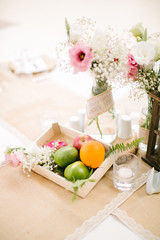Wedding dining table and colorful flowers. Wedding day and wedding dining table. Fruit basket, apple, orange, lime.