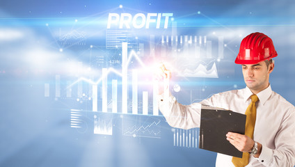 Handsome businessman with helmet drawing PROFIT inscription, architecture business plan concept