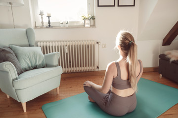Junge Frau sitzt auf dem Boden und schaut aus dem Fenster