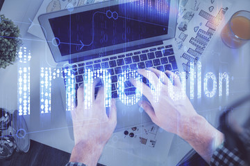 Double exposure of man's hands typing over computer keyboard and data theme hologram drawing. Top view. Technology concept.