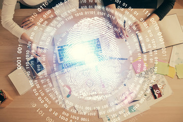 Double exposure of woman hands working on computer and fingerprint hologram drawing. Top View. Digital Security concept.