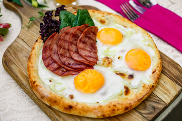 Bacon and eggs on a wheat cake with greens for lunch