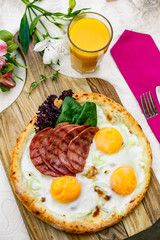 Bacon and eggs on a wheat cake with greens for lunch