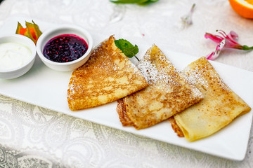 pancakes with powdered sugar berries and jam for breakfast