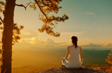 Silhouette meditation yoga woman for relax vitality and energy in the morning on the high mountains