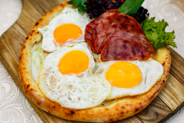Bacon and eggs on a wheat cake with greens for lunch