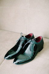 Black patent leather wedding shoes. Wedding reparations details. Indoor and close up.
