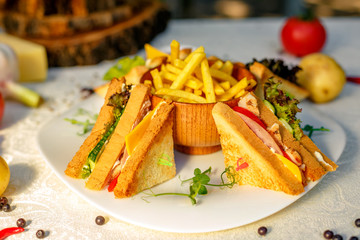 sandwiches with fresh vegetables and chicken with fried potatoes on a white tablecloth