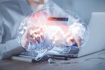 Double exposure of man hands typing on computer with credit card and brain theme drawing....