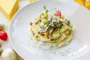 Spaghetti Carbonara - pasta with smoked bacon and mushrooms in creamy sauce and Parmesan cheese
