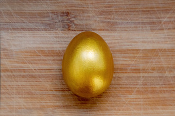 Ester golden egg on wooden rustic table.