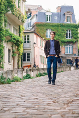 Fototapeta na wymiar a man in a jacket and jeans walks in Montmartre, Paris