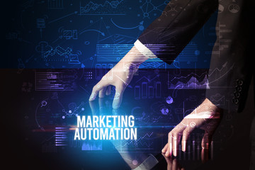 Businessman touching huge screen with MARKETING AUTOMATION inscription, cyber business concept