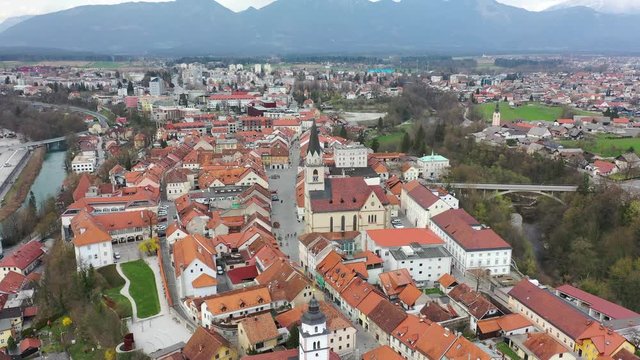 Forward slow flying drone over medieval downtown of Kranj town, Slovenia over main promenade street