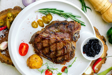 juicy barbecue steak with pickled onions and jalapeno on a white plate