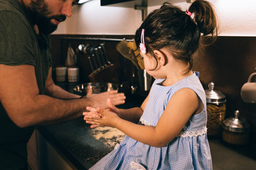 daughter and father preparing meatballs in the home kitchen during the quarantine