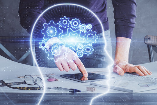 Double exposure of man's hand holding and using a digital device and brain hologram drawing. Data concept.