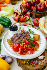 BBQ, juicy steak with grilled vegetables and sauce on a white plate