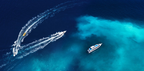 Fast boats on the sea in Bali, Indonesia. Aerial view on speed boats on blue water at sunny day....
