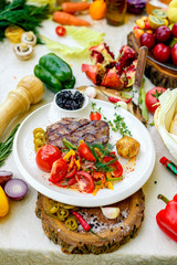 BBQ, juicy steak with grilled vegetables and sauce on a white plate