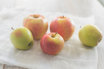 Five apples on the white textile