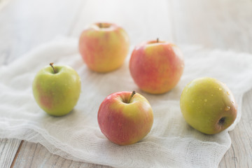 Five apples on the white textile