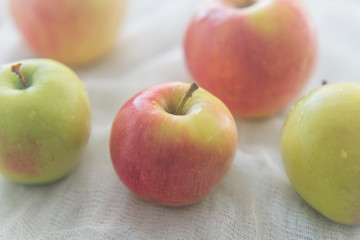 Five apples on the white textile
