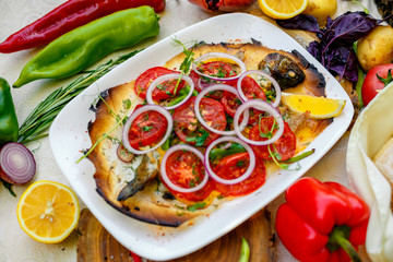 hot smoked fish koktal, Kazakh dish, with vegetables, tomatoes and onions on a festive table, special dish